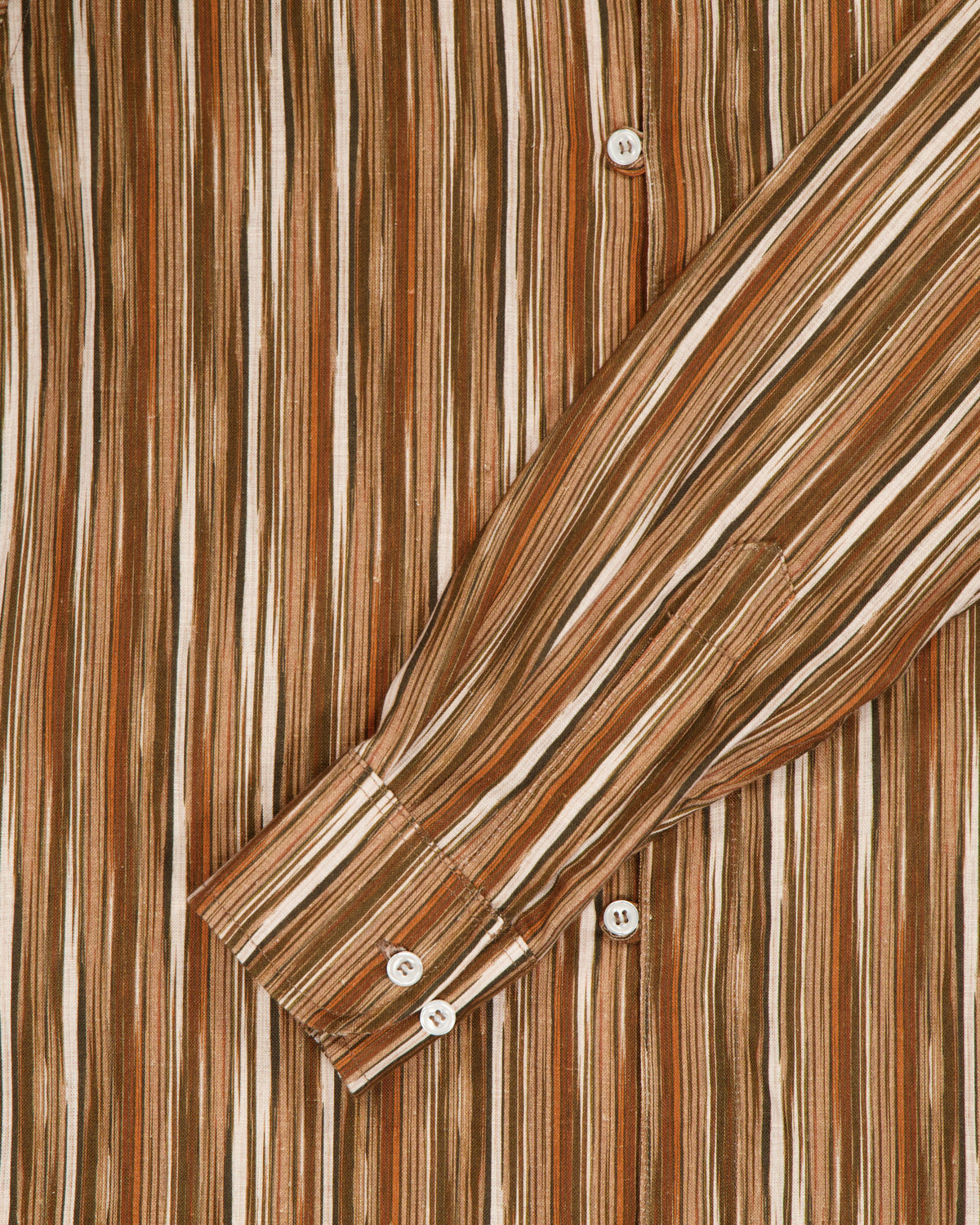 Close up of sleeve from a striped belgian linen shirt. 